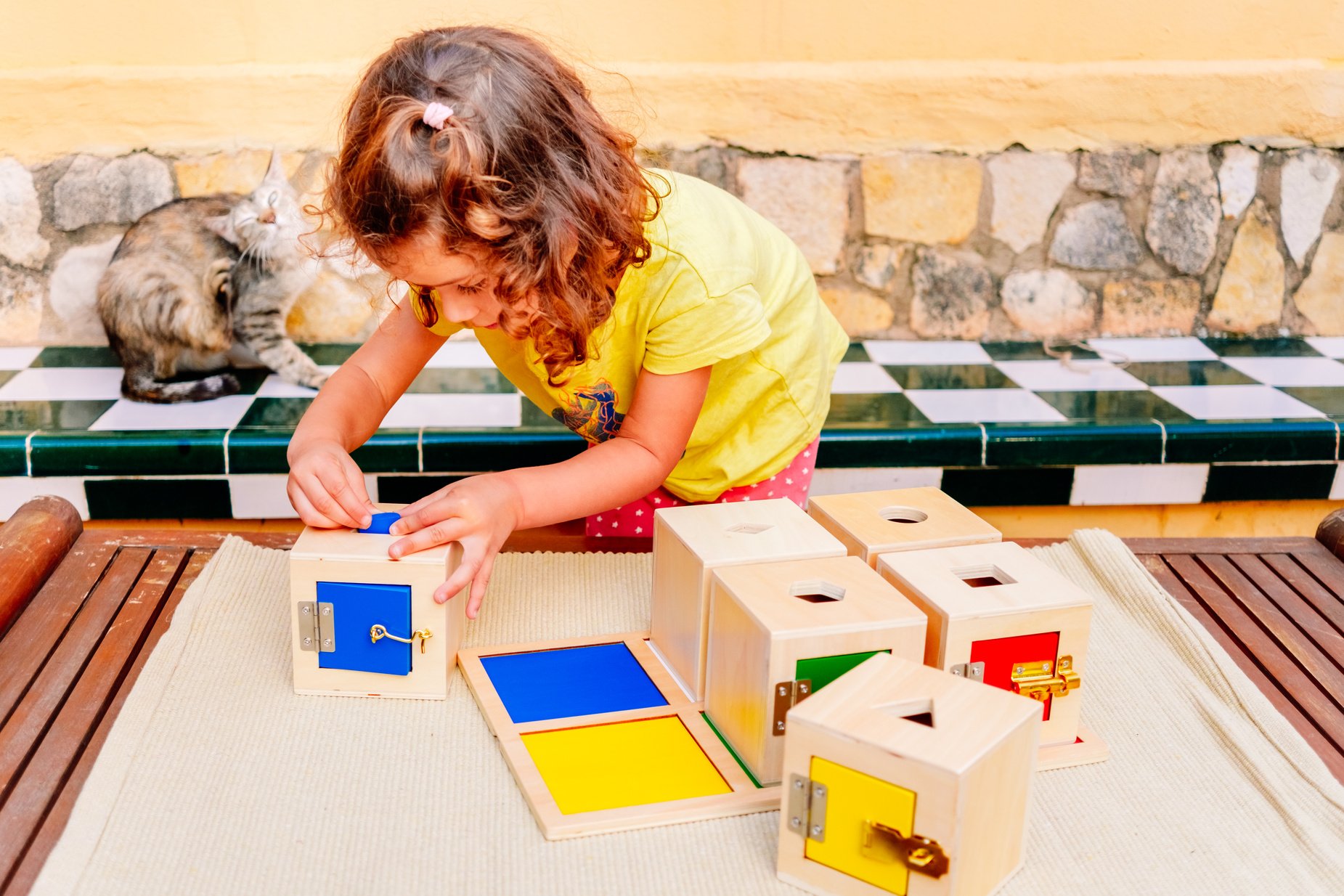 A Girl Manipulates Sensory Montessori Material, Wooden Boxes to