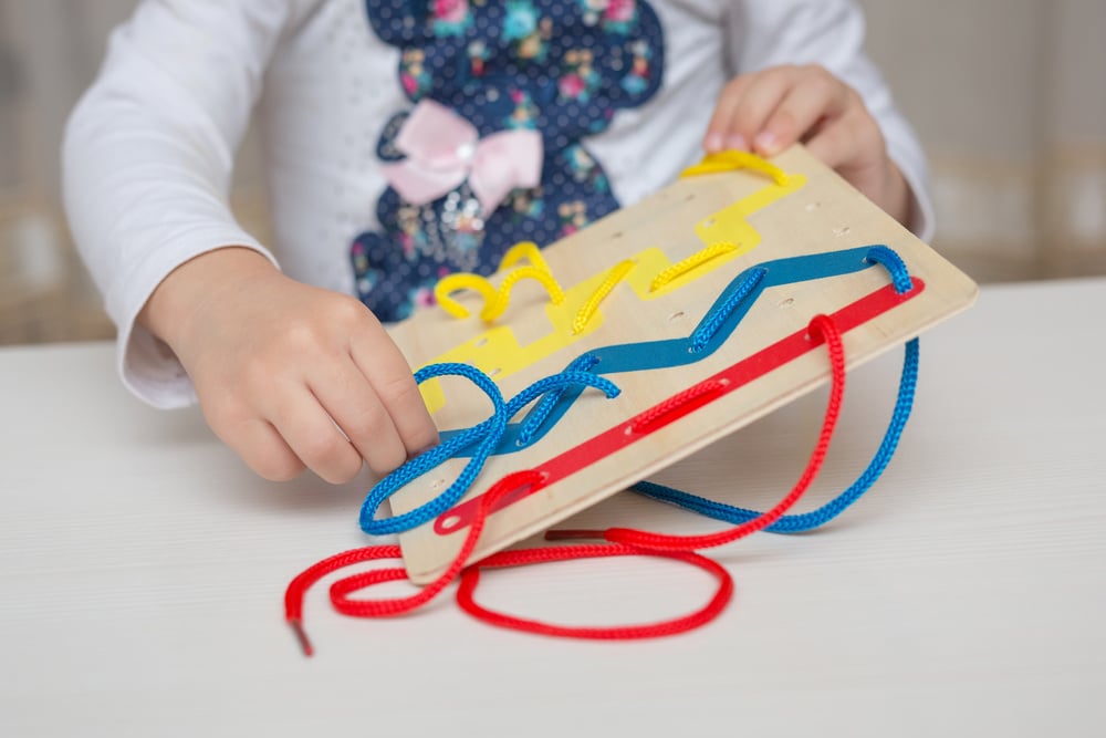 Girl playing with developmental aid. Montessori pedagogical system.